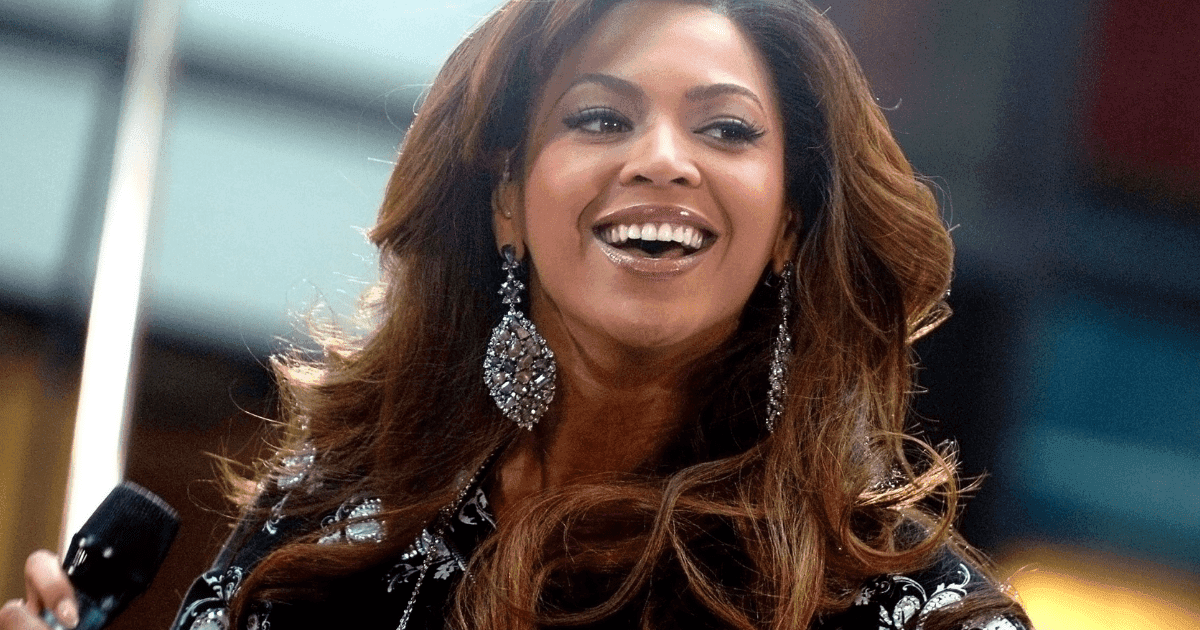Beyonce and cbd: a portrait photo of the singer beyonce in a black and white top with her hair tied back. She is wearing red lipstick