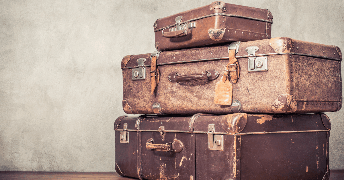 Canna-emigration: a pile of three brown suitcases in a brown room