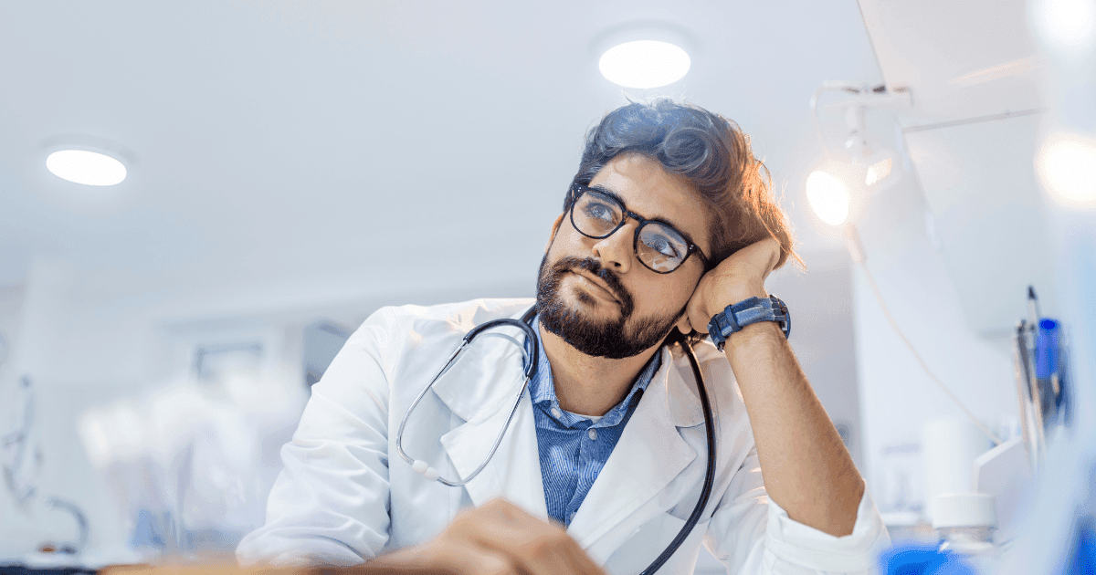 Frontline workers: A doctor in a white lab coat sits with his head in hands