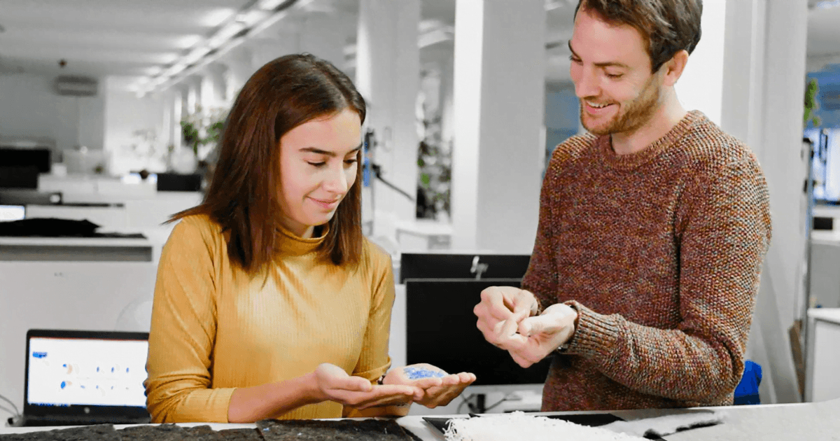 BMW: A man and a woman examine different panels of material at a desk in a white office room
