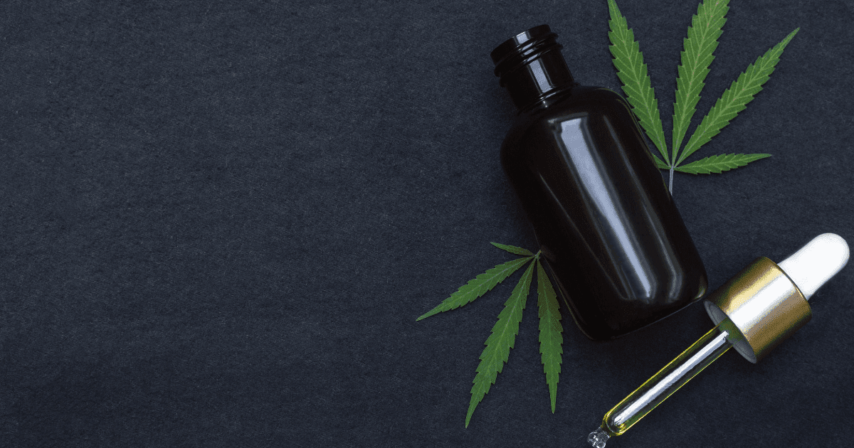 Trigeminal Neuralgia: A bottle of CBD oil against a dark background with two cannabis leaves beside it.