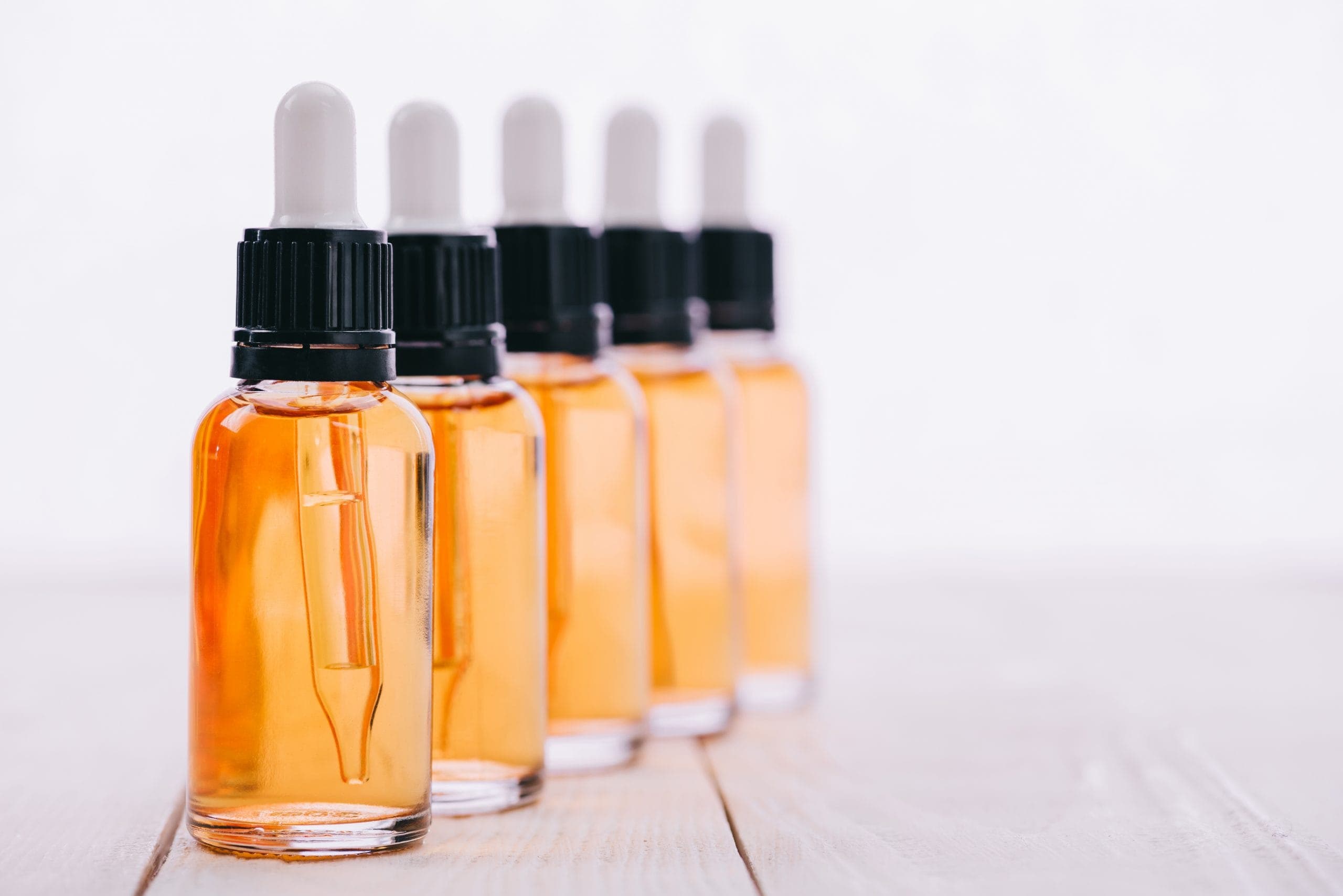 Clint Eastwood: A row of glass bottles with yellow CBD oil them