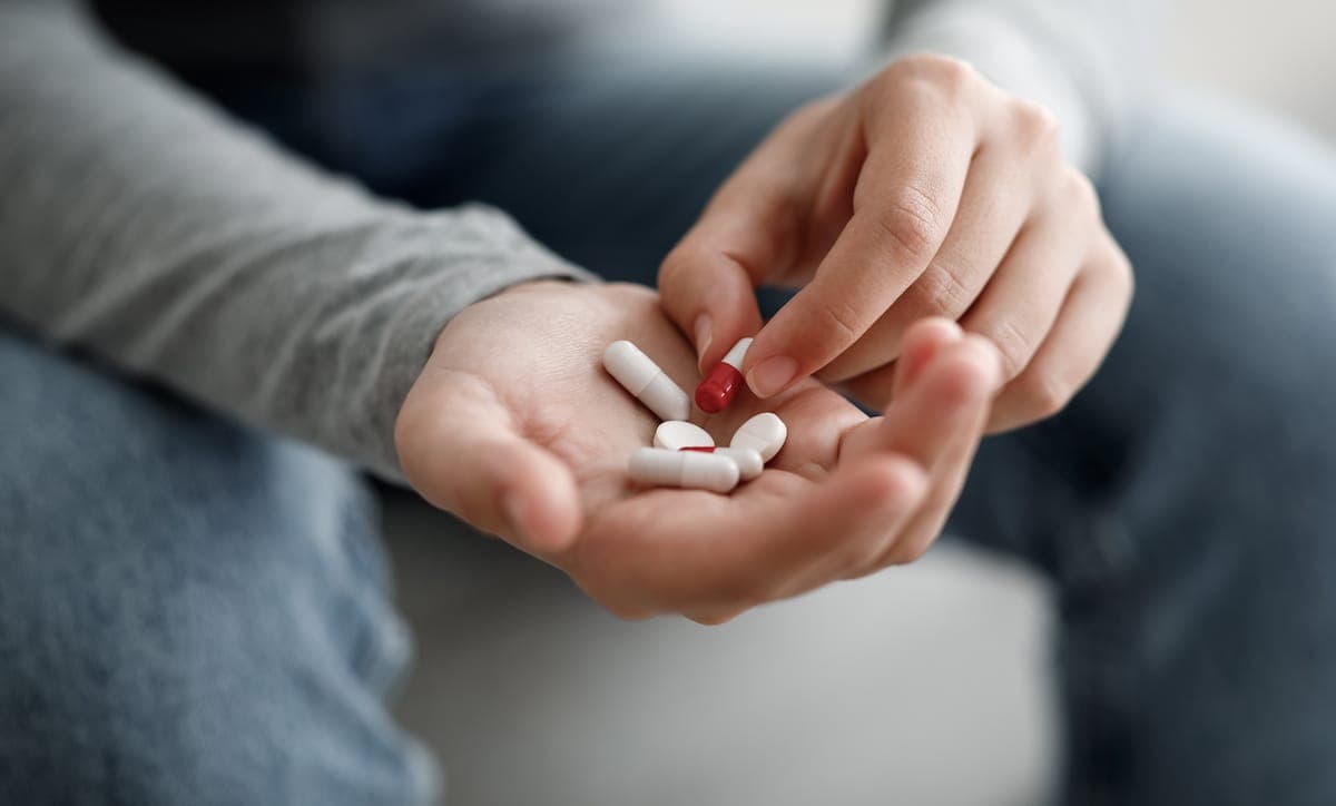 antidepressants: woman suffering from depression holds pills on her hand