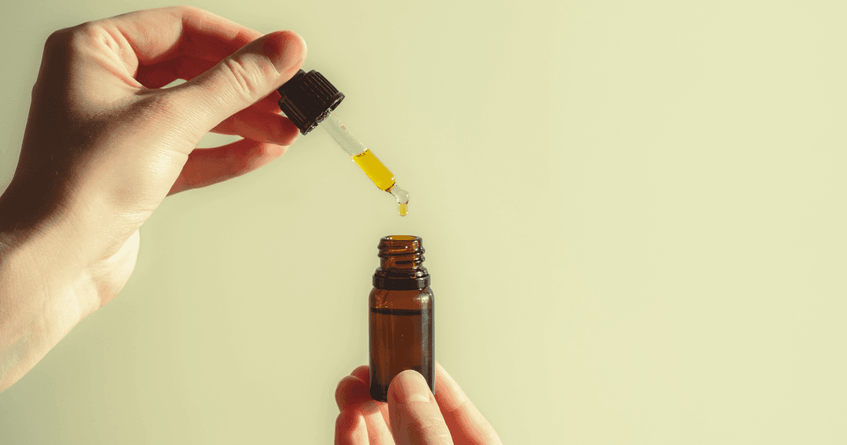 Autism: A hand pouring CBD-dominant oil into a small brown bottle