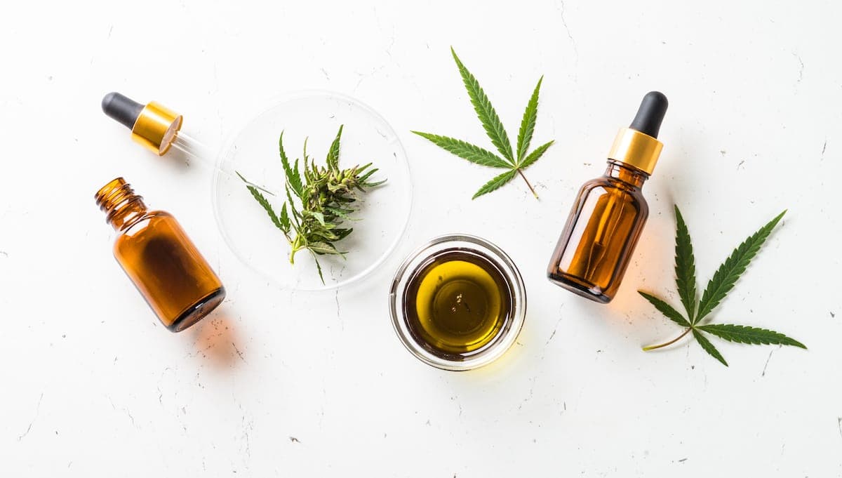 A collection of CBD bottles and cannabis leaves on a white background