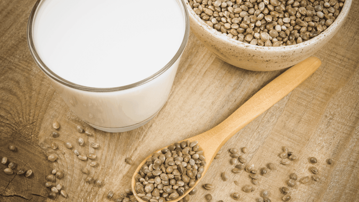 Hemp milk: A glass of hemp milk and seeds on a wooden surface