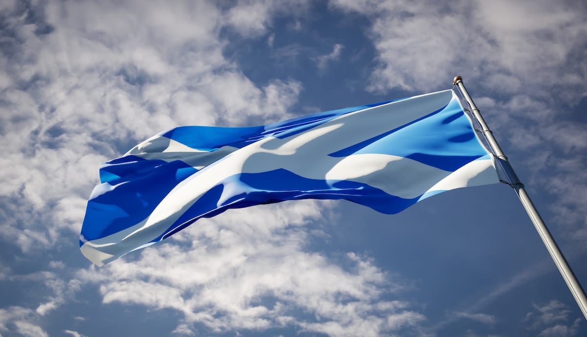 Scottish flag against a blue sky backdrop with clouds