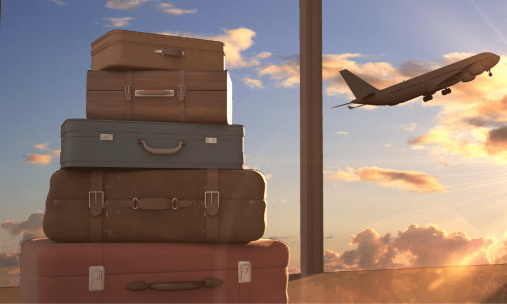 Emigration: A stack of suitcases against a window revealing a sunset and a plane