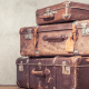Canna-emigration: a pile of three brown suitcases in a brown room