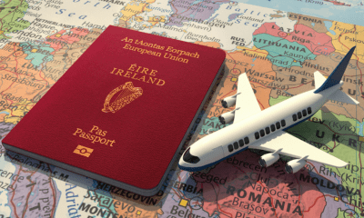 Canna emigration: An Irish passport lying on a map with a small toy airplane next to it