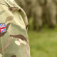 Veterans and CBD: The shoulder of an army person wearing green combat gear with a British flag. on it