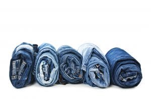 Climate change: A line of blue denim jeans rolled tightly into balls