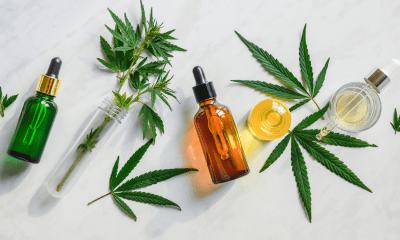 The best way: A vape, a brown bottle of oil and a yellow oil lie on their sides surrounded by cannabis leaves on a white background