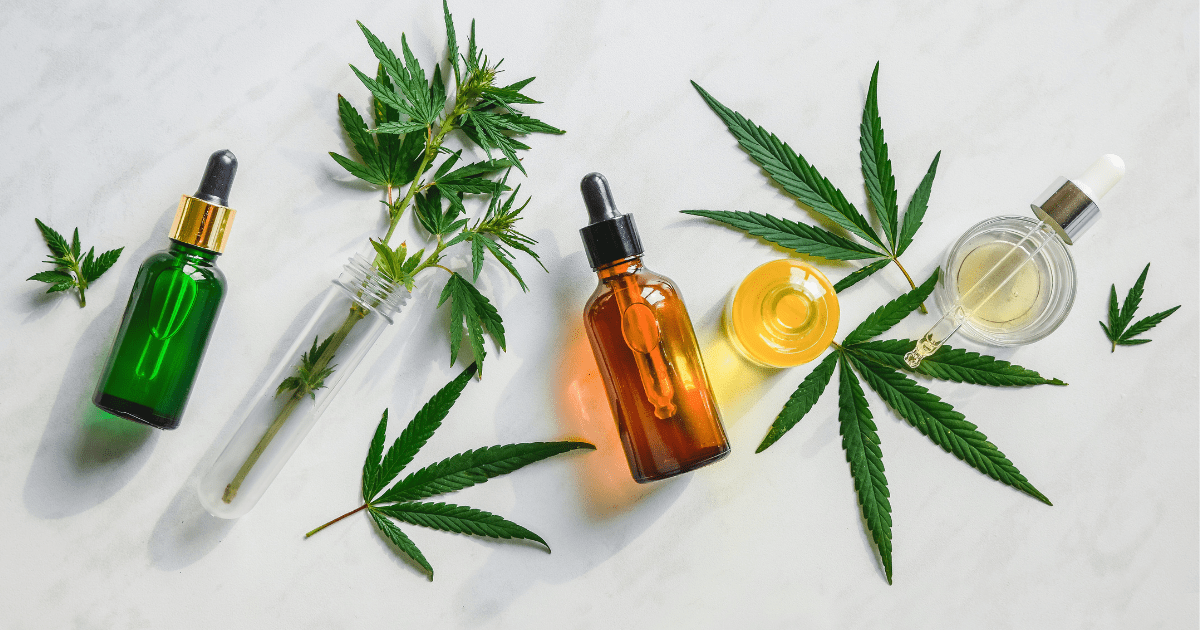 The best way: A vape, a brown bottle of oil and a yellow oil lie on their sides surrounded by cannabis leaves on a white background