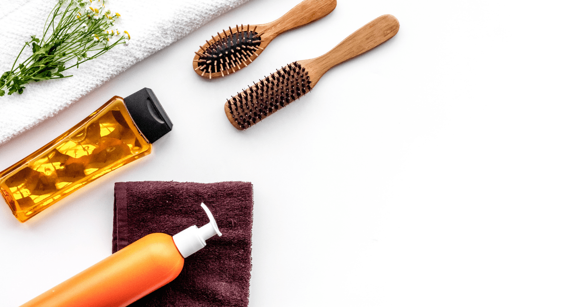 Alopecia: A number of hair products on a white background including two hairbrushes, a bottle of oil, a spray bottle and two towels