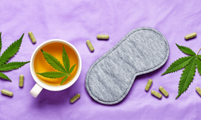 Insomnia: A sleep mask, cannabis leaves, capsules and a cup of tea with a cannabis leaf sit on a purple duvet