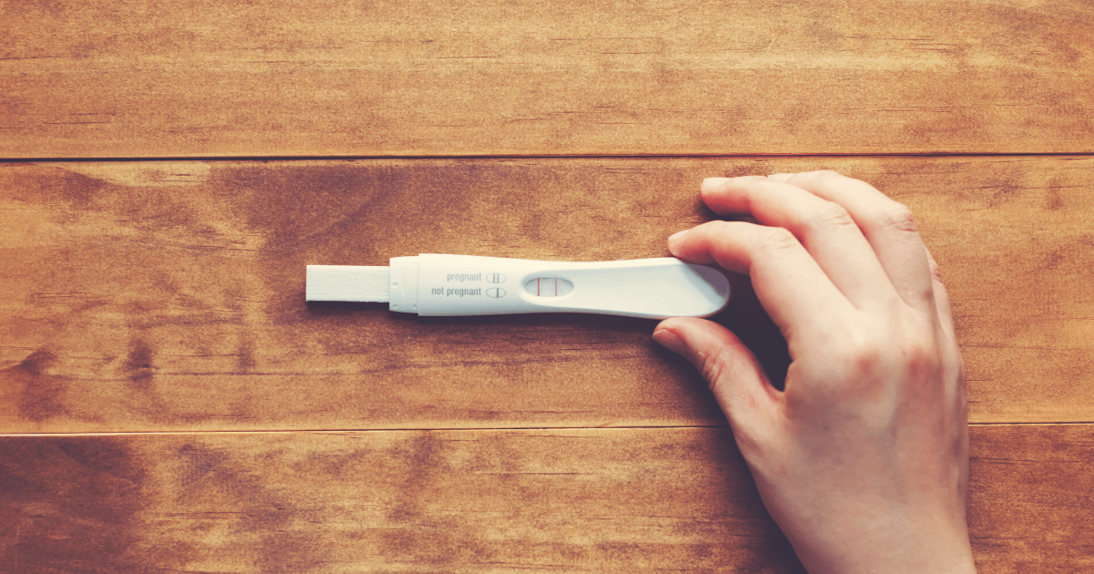 Pregnant: A person holding a pregnancy test that is positive