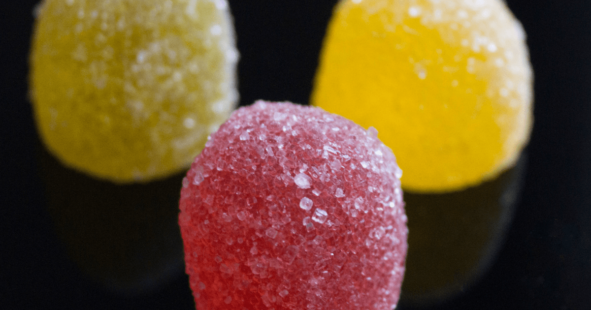 BROWNS CBD: Three gummy sweets in red, green and yellow on a black background