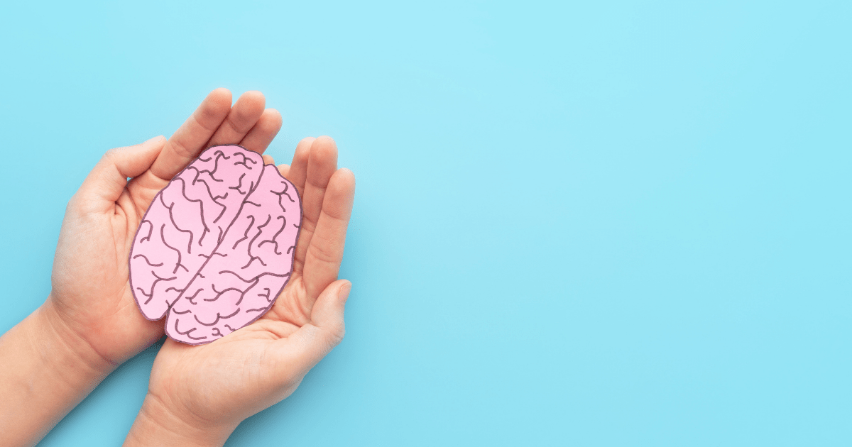 Schizophrenia: Two hands holding a pink paper brain