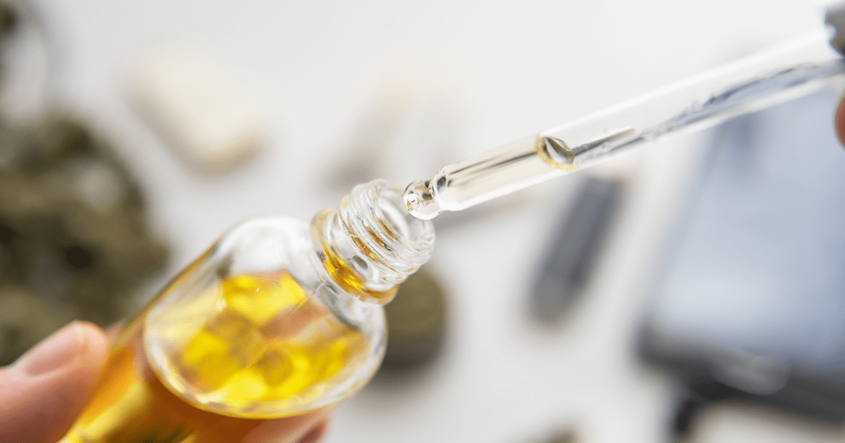 Patients: A person holding a bottle of yellow cannabis oil with a dropper