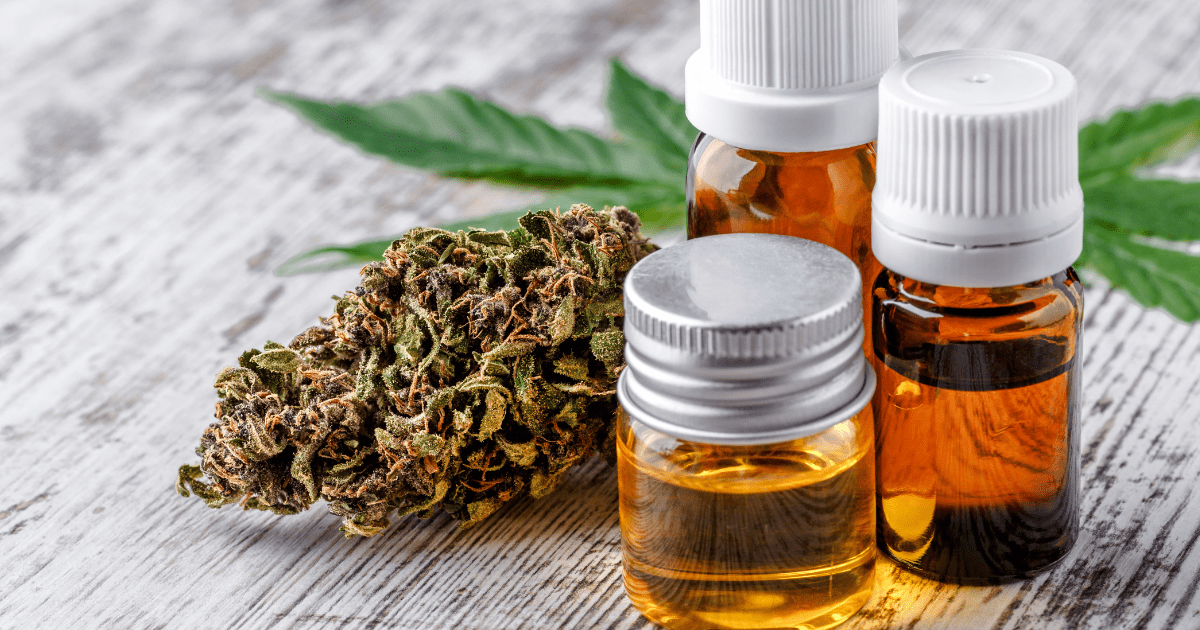 Patients: A collection of brown bottles containing CBD oil, cannabis and a green cannabis leaf on a wooden surface