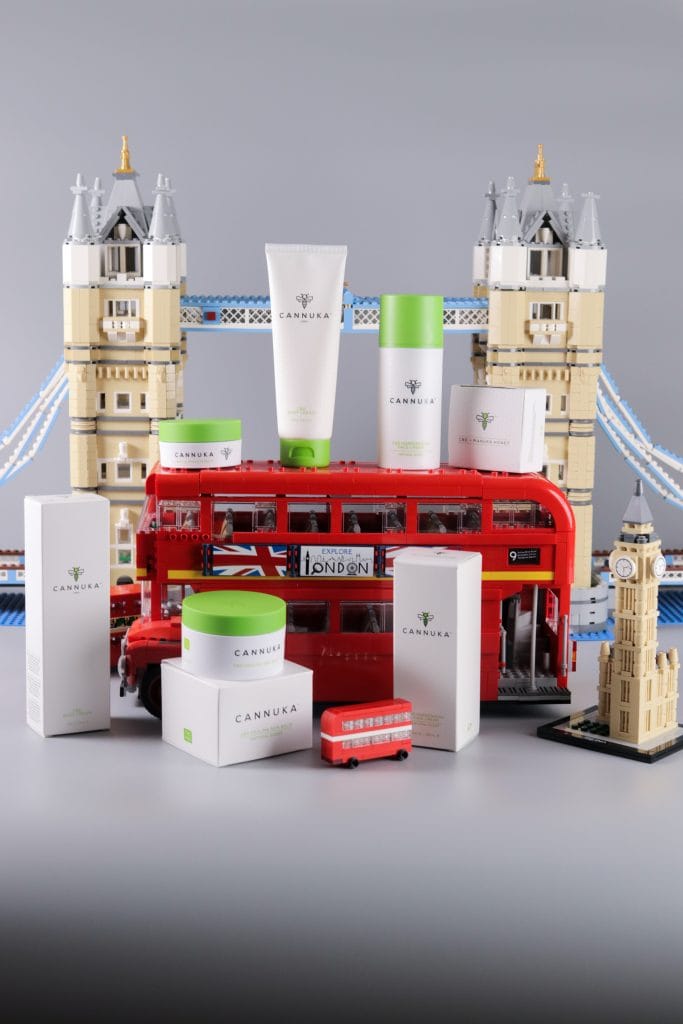 Cannuka: A selection of products with a red London bus to highlight the brand's UK launch