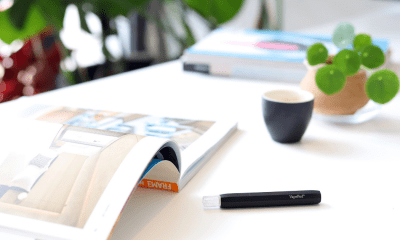 Kanabo: A vape lying on a magazine with a cup of coffee nearby