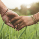 An illustration of a couple holding hands in a field of grass