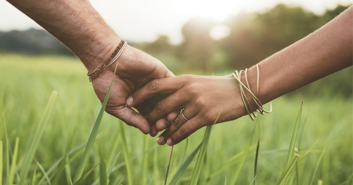 An illustration of a couple holding hands in a field of grass