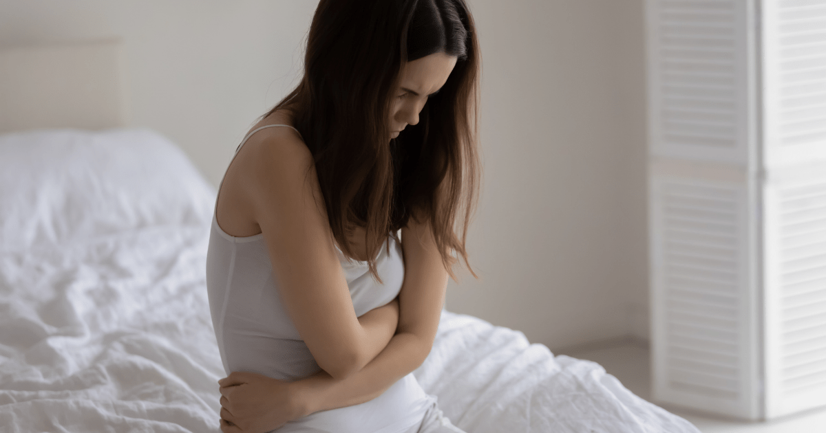 IBD: A woman holding her stomach in pain from IBD