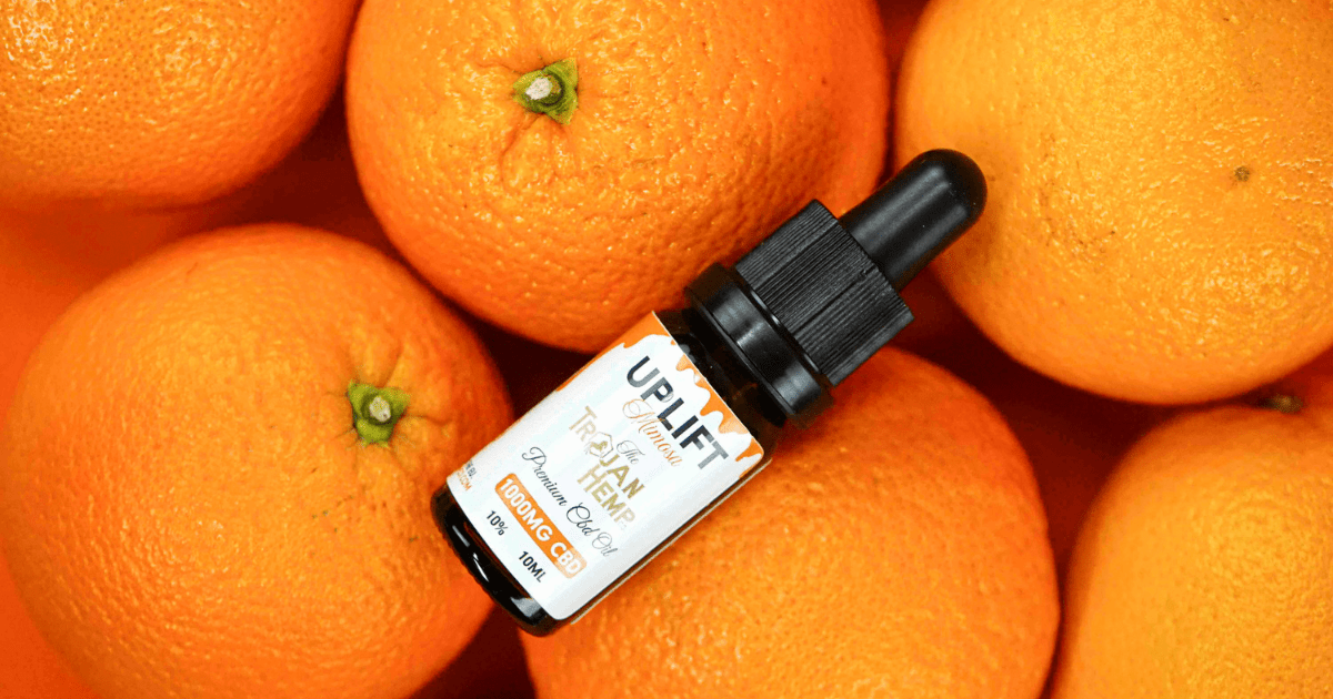 Trojan Hemp Co.: A collection of oranges with a bottle of Uplift CBD on top