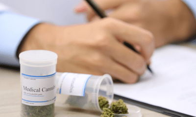 : A person writing on a medical notepad prescribing medical cannabis