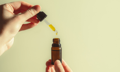 Autism: A hand pouring CBD-dominant oil into a small brown bottle