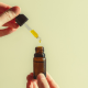 Autism: A hand pouring CBD-dominant oil into a small brown bottle